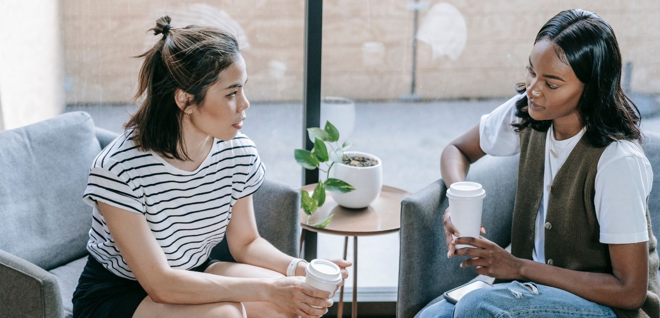 Two people drinking coffee and chatting